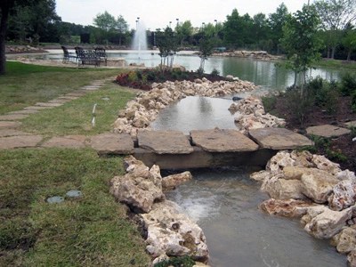 Front yard landscape feature with plants and stones